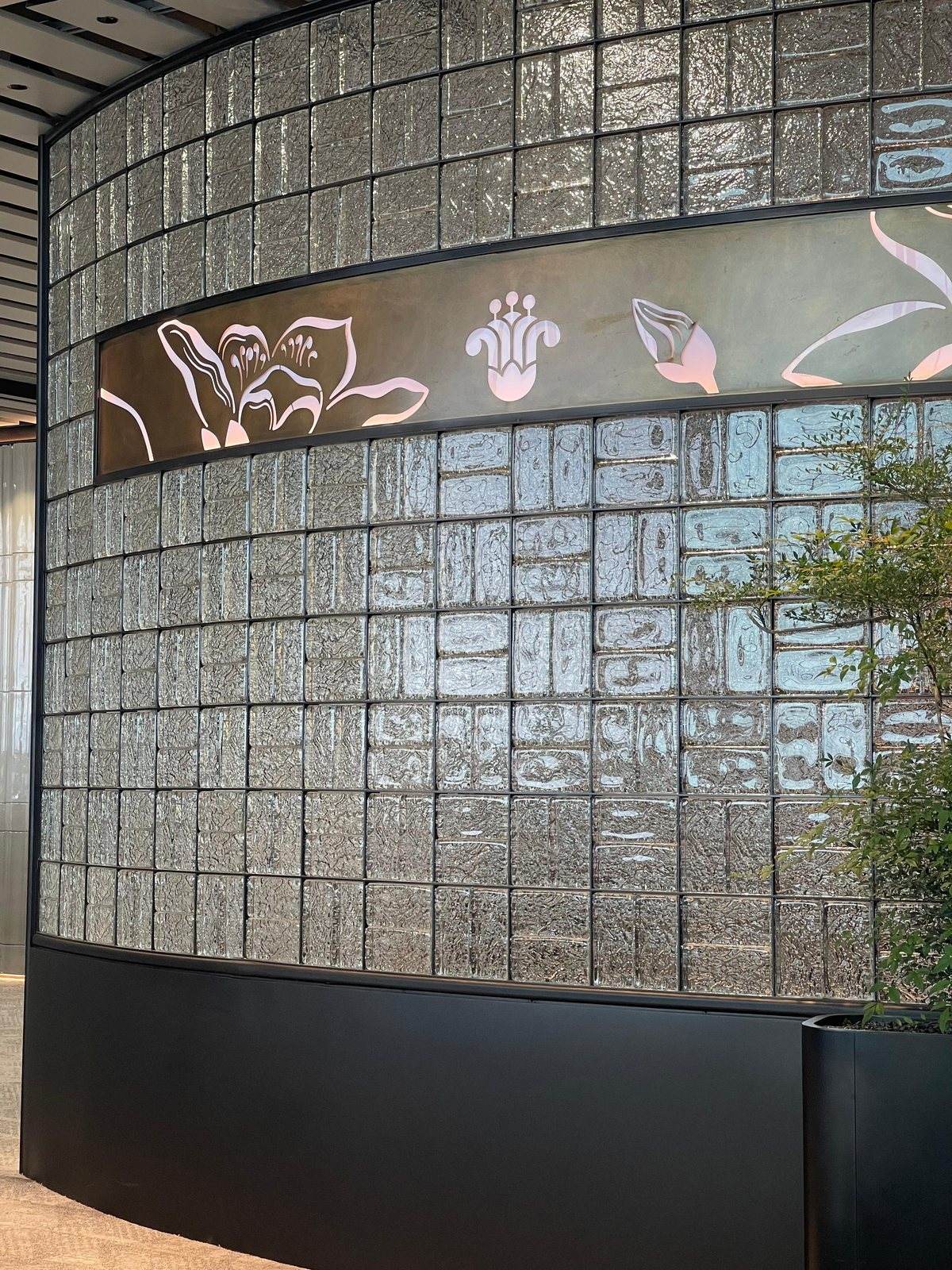 Curved glass brick partition wall in an international airport lounge by ETERNAL