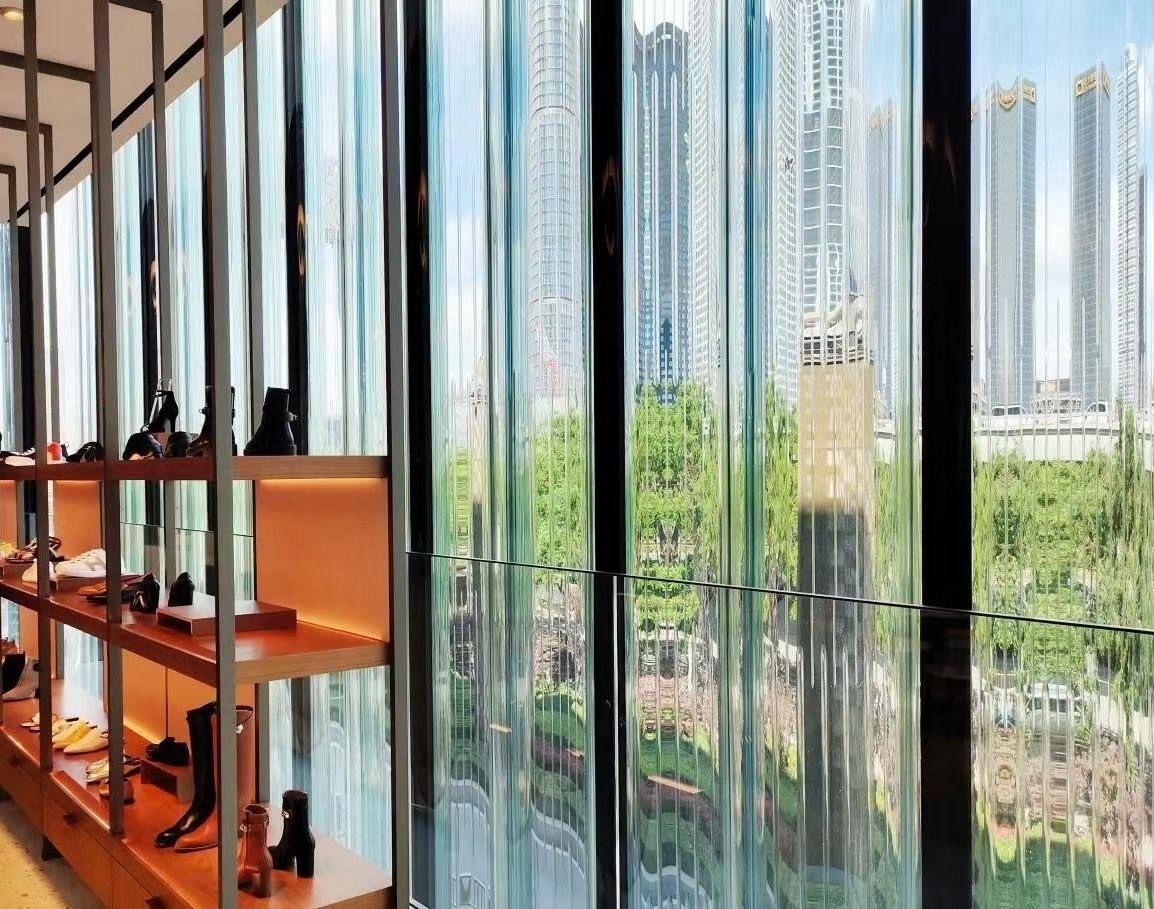 Store view through the fluted glass — 国际奢侈品牌门店 · 热弯竖纹玻璃幕墙项目